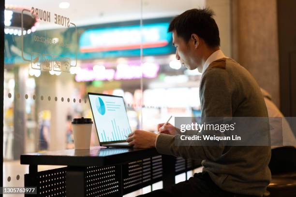 asian man using laptop in shop - infographics business store stock pictures, royalty-free photos & images