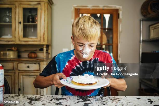 boy with whipped cream on face holding plate of pancakes - whip stock pictures, royalty-free photos & images