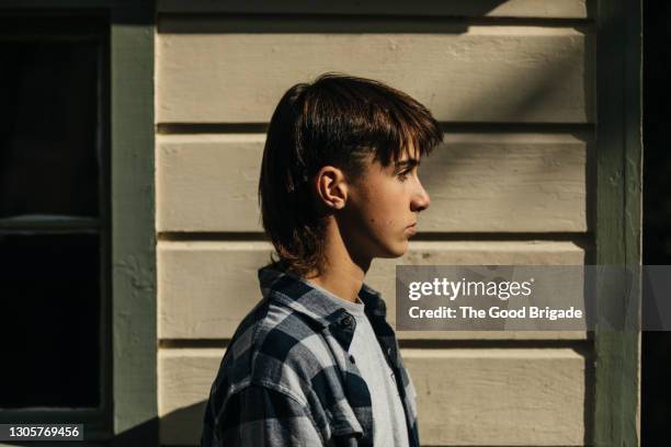 portrait of serious teenage boy outdoors by house - mullet hairstyle stock pictures, royalty-free photos & images