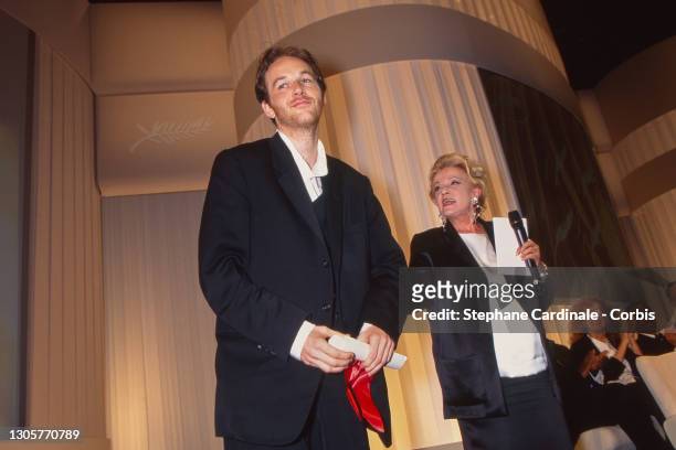 Director Xavier Beauvois pose on stage with his Prize « Prix Du Jury » next to Jeanne Moreau on stage during the Closing Ceremony of the 48th Annual...