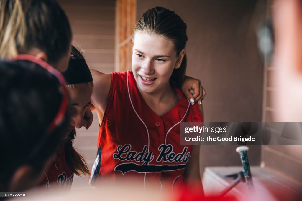 Girl softball team meeting in dugout