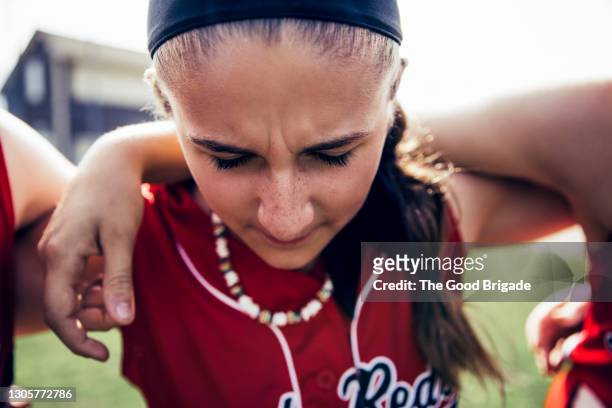 girl softball team huddle on field before game - girls team sport stock pictures, royalty-free photos & images