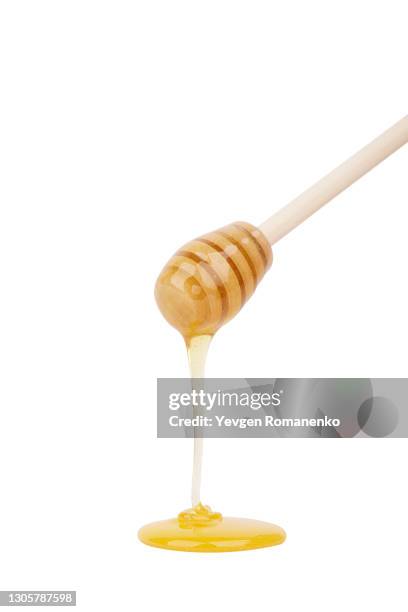 wooden honey dipper with flowing honey isolated on white background - honey stockfoto's en -beelden