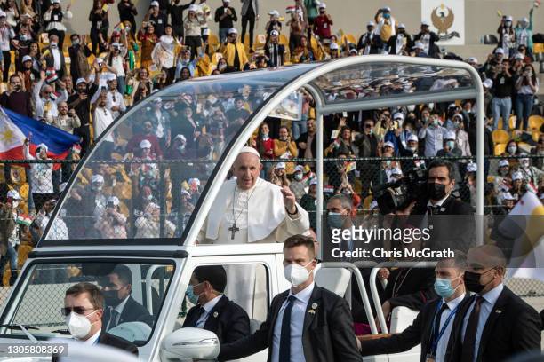 Pope Francis waves to the crowd as he arrives to conduct mass at the Franso Hariri Stadium on March 07, 2021 in Erbil, Iraq. Pope Francis arrived in...