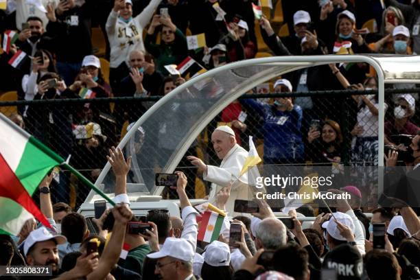 Pope Francis waves to the crowd as he arrives to conduct mass at the Franso Hariri Stadium on March 07, 2021 in Erbil, Iraq. Pope Francis arrived in...