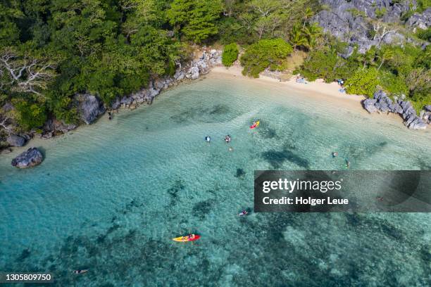 aerial of passengers of cruise ship mv reef endeavour (captain cook cruises fiji) relaxing and enjoying watersports at blue lagoon beach - fiji cruise stock pictures, royalty-free photos & images