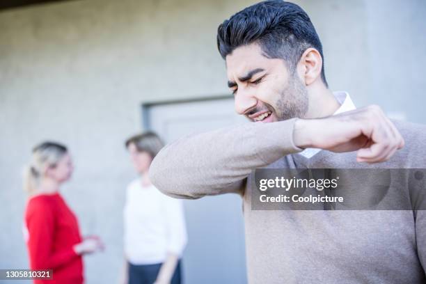 man sneezing in ellbow. - covering cough stock pictures, royalty-free photos & images