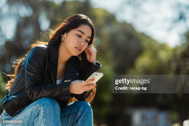 young woman enjoying listening to music in public park - pessoas bonitas imagens e fotografias de stock