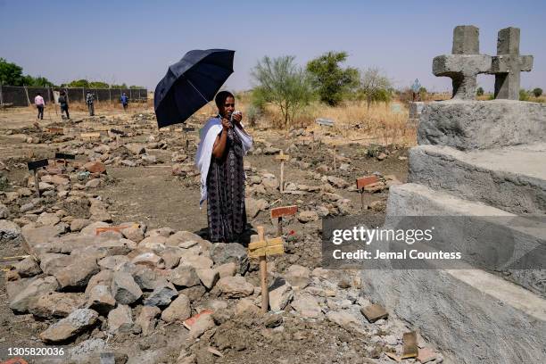 Agere Getnet weeps in front of a tomb containing the remains of her husband, Tebekaw his younger brother, Alie Abere, and his nephew, Aynew Mulat,...