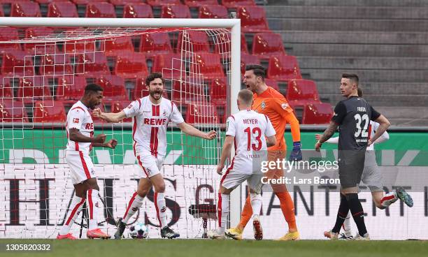 Jonas Hector of 1. FC Koeln celebrates after scoring their side's first goal as Jiri Pavlenka of SV Werder Bremen reacts during the Bundesliga match...