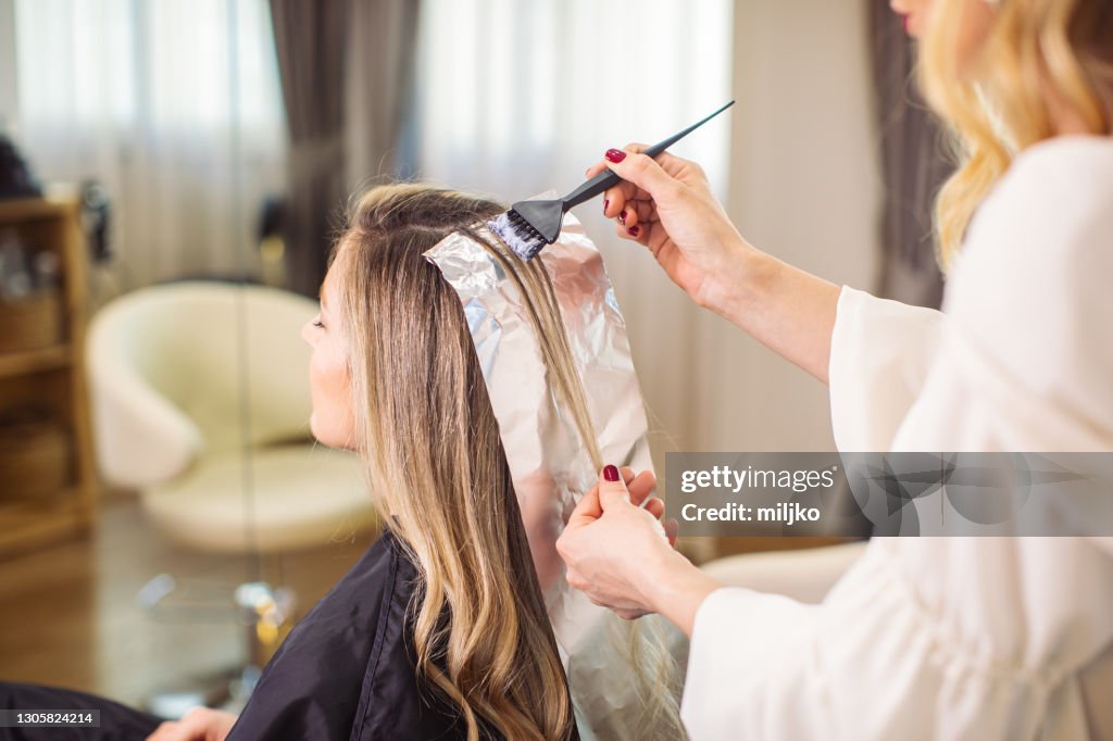 Woman dyeing her hair at the salon