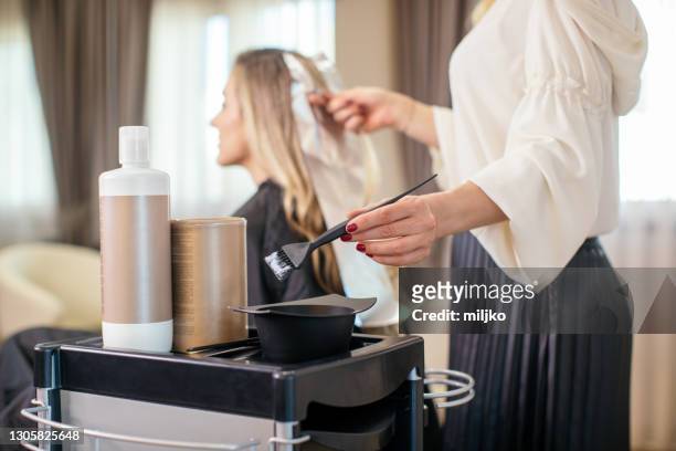 woman dyeing her hair at the salon - dye imagens e fotografias de stock
