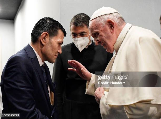 In this photograph provided by Vatican Media, Pope Francis meets Abdullah Kurdi at the end of a mass at Erbil's Franso Hariri Stadium, on March 07,...