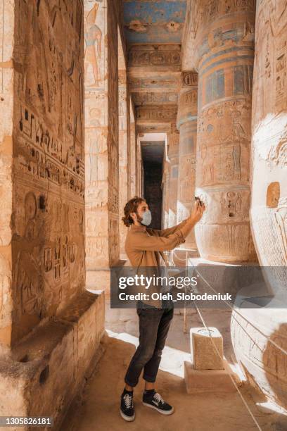 man walking in the ancient egyptian temple in luxor - middle eastern male on phone isolated stock pictures, royalty-free photos & images