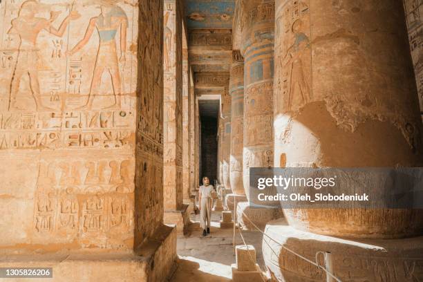 woman walking in the ancient egyptian temple in luxor - egypt temple stock pictures, royalty-free photos & images