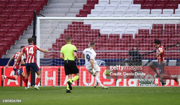 Karim Benzema of Real Madrid scores their side's first goal during the La Liga Santander match between Atletico de Madrid and Real Madrid at Estadio...