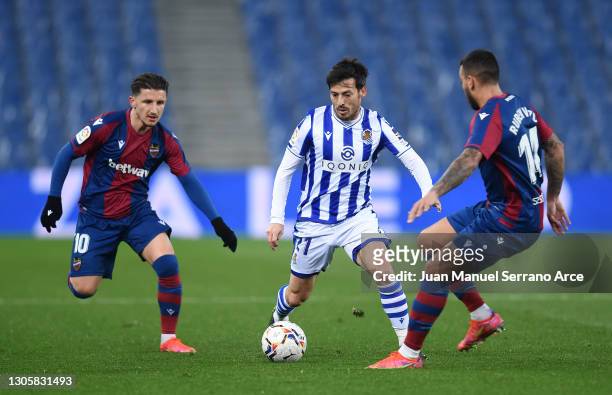 David Silva of Real Sociedad controls the ball whilst under pressure from Enis Bardhi of Levante UD and Ruben Vezo of Levante UD during the La Liga...