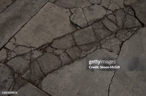 cracked concrete footpath and driveway - bad road stock pictures, royalty-free photos & images
