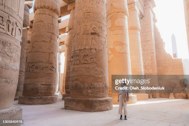 mujer caminando en el antiguo templo egipcio en luxor - egipcio fotografías e imágenes de stock