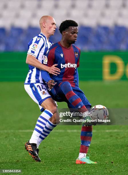 Jon Guridi of Real Sociedad competes for the ball with Mickael Malsa of Levante UD during the La Liga Santander match between Real Sociedad and...