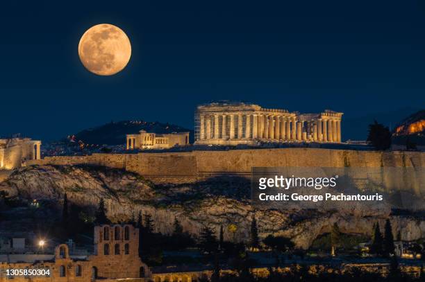 full moon over the acropolis of athens, greece - acropolis greece stock pictures, royalty-free photos & images