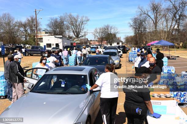 Volunteers help to distribute water at a water and food distribution drive held by College Hill Baptist Church and the World Central kitchen on March...