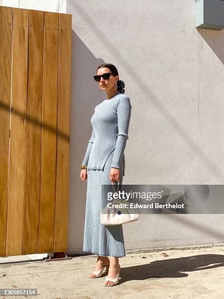 Julia Comil wears Saint Laurent YSL sunglasses, earrings, a metallic chain bracelet, a wool gray rib top by Theory, a soft cotton rib skirt by...