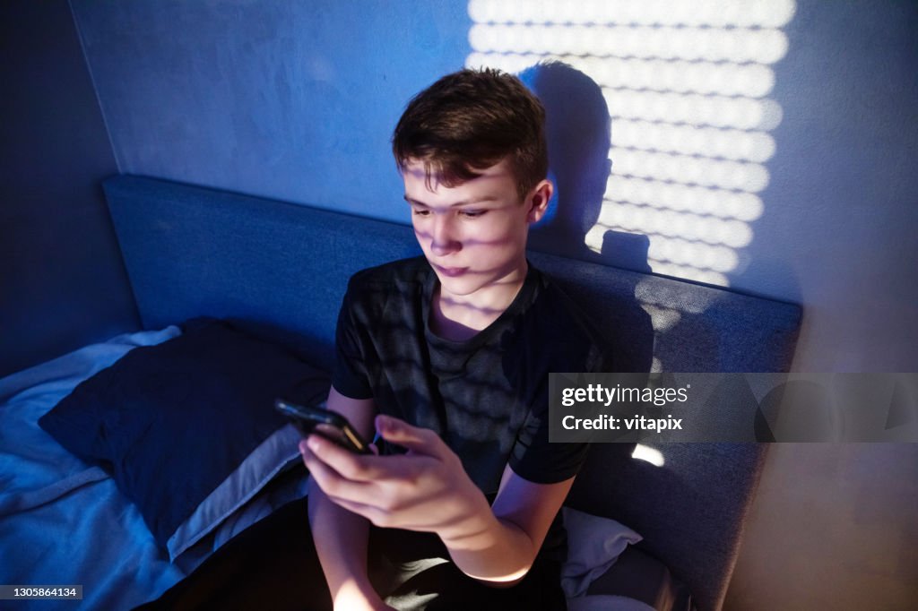 Teenager Using Cell Phone at Night