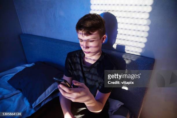 teenager using cell phone at night - scared boy imagens e fotografias de stock
