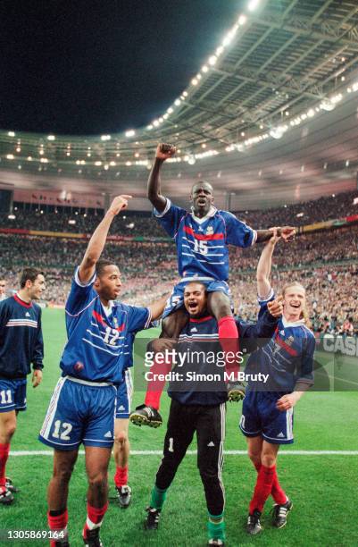 Lilian Thuram on the shoulders of Bernard Lama with Thierry Henry and Emmanuel Petit of France celebrate after victory during the World Cup semi...