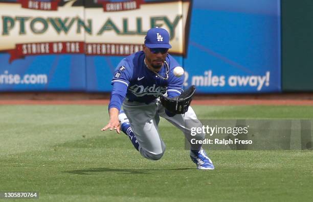 Outfielder Mookie Betts of the Los Angeles Dodgers eyes a line drive off the bat of Khris Davis of the Texas Rangers during the first inning of the...