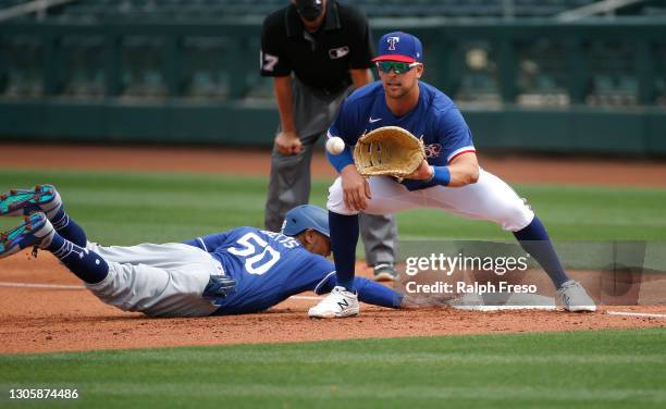 First baseman Nate Lowe of the Texas Rangers fields a throw on a pick-off attempt of base runner Mookie Betts of the Los Angeles Dodgers in the...