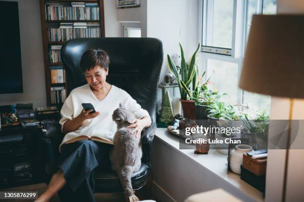 senior asian woman using a smartphone - hand sign stock pictures, royalty-free photos & images