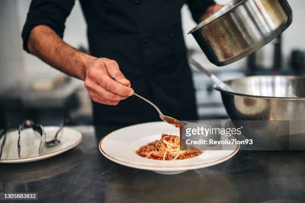 male chef prepare pasta in restaurants kitchen - chef coat stock pictures, royalty-free photos & images