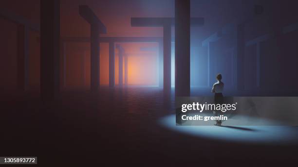 businesswoman lost in dark concrete maze - woman spotlight stock pictures, royalty-free photos & images