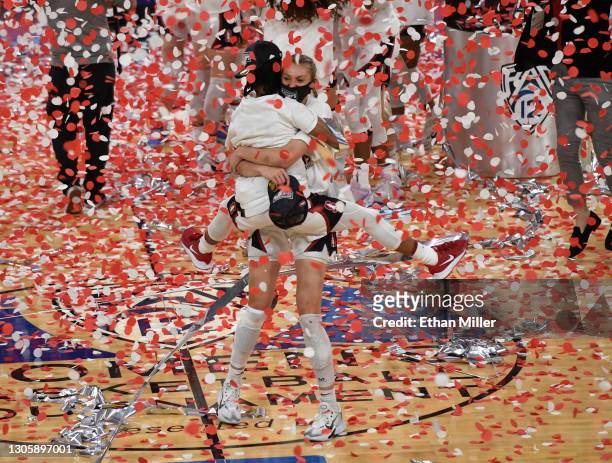 Cameron Brink of the Stanford Cardinal picks up teammate Kiana Williams as they celebrate their 75-55 victory over the UCLA Bruins to win the...