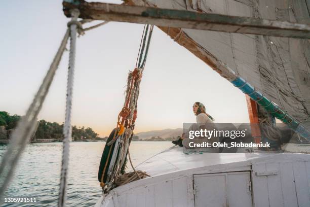 vrouw die op felucca op de nijl bij zonsondergang reist - nile river stockfoto's en -beelden