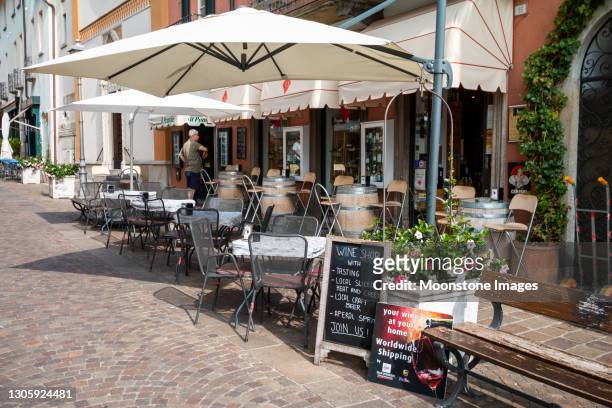 sidewalk cafe auf via calvi in menaggio, italien - gartenschirm stock-fotos und bilder