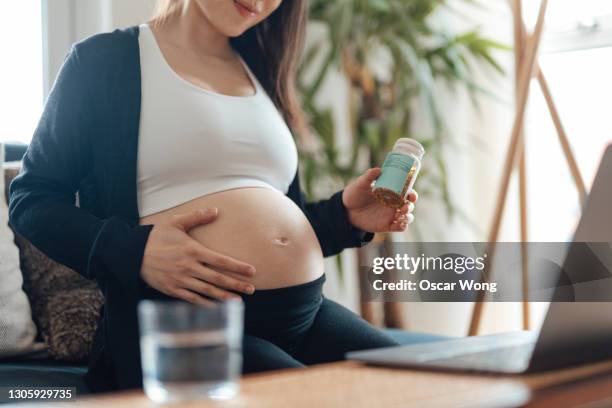 pregnant woman having video call with doctor using laptop at home - consulate stock pictures, royalty-free photos & images