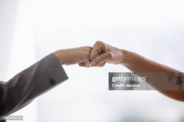 avoiding handshakes and greeting with fist bump - covid greeting stock pictures, royalty-free photos & images