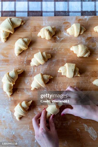 woman rolling croissant dough on cutting board - puff pastry stock pictures, royalty-free photos & images