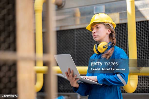 female service engineer examining cooling tower system by computer software on rooftop of industrial plant. - air duct repair stock pictures, royalty-free photos & images