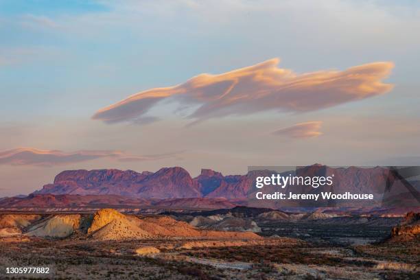 view of the chisos mountains with a lenticular cloud at sunset - chisos mountains stock pictures, royalty-free photos & images