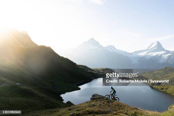 hiker with mountain bike at bachalpsee lake, switzerland - turismo ecológico fotografías e imágenes de stock
