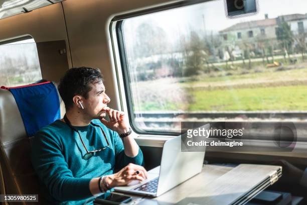 empresário trabalhando em trem com laptop - homens de idade mediana - fotografias e filmes do acervo