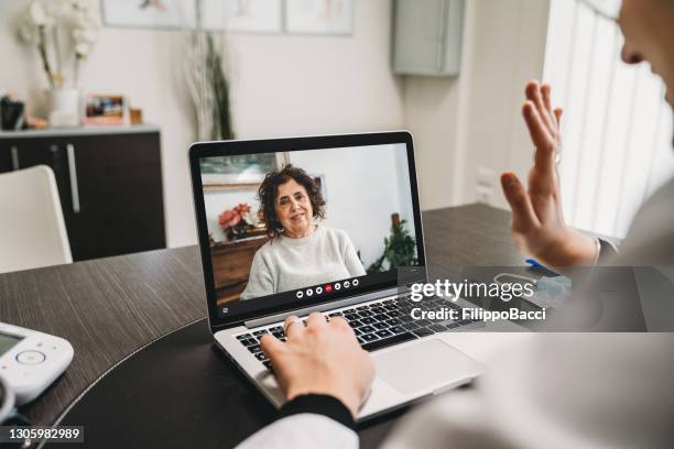 young female doctor is having a video call with a patient - telehealth visit stock pictures, royalty-free photos & images