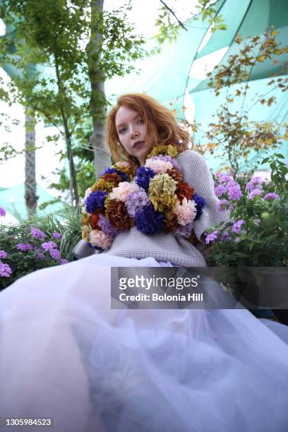 mujer joven pelirroja posando con vestido lila y collar de flores - vestido de flores stockfoto's en -beelden