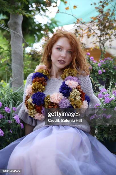 mujer joven pelirroja posando con vestido lila y collar de flores - vestido de flores stock pictures, royalty-free photos & images