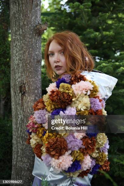 mujer joven pelirroja posando sobre árbol con chaqueta de flores - chaqueta de flores stockfoto's en -beelden