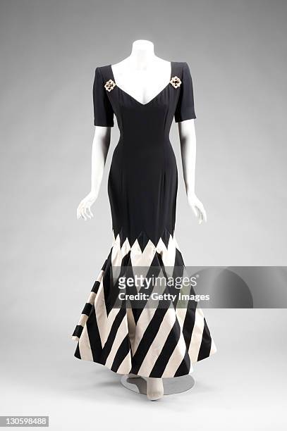 Black silk crepe, short sleeve gown with black and white striped silk satin trumpet hem. The gown features faux jeweled brooches at shoulders and...